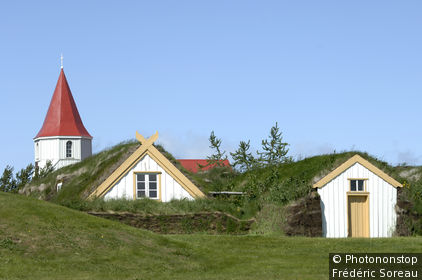 Islande, environs de Varmahlid, ferme de Glaumbaer recouverte de gazon, clocher en arrière-plan