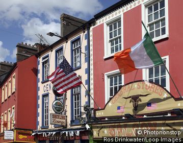 Republic of Ireland, County Monaghan, Carrickmacross. US and Irish flags flying ouside a General Stores in Main Street, Carrickmacross.
