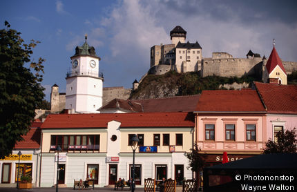 Slovakia, Eastern Europe, Trencin, Old town with gate tower and castle on hill in distance.
