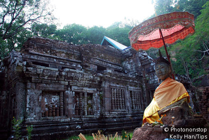 Laos, Champasak, Statue of Buddha in Front of the Ruins of a Buddhist Temple.